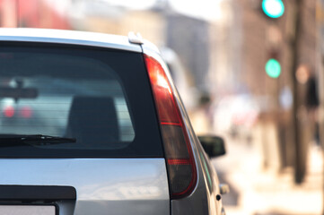 Dark window of gray car parked on the street in summer sunny day, rear view. Mock-up for sticker or decals