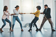 © Camerene Pendl/peopleimages.com - Its a competitive market out there with many challenges. Shot of a group of businesspeople pulling on a rope during tug of war in an office.