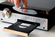 © Joose - hand putting a cd disc into a music player