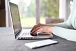 © YarikL - Businesswoman's hands presses on a laptop keyboard, Using computers. Remote working from home. Freelancer workplace in kitchen with laptop