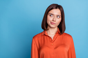 Photo of young pretty woman minded look empty space thoughtful plan isolated over blue color background