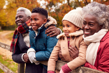 Wall Mural - Grandparents By Gate With Grandchildren On Walk Through Autumn Countryside Together