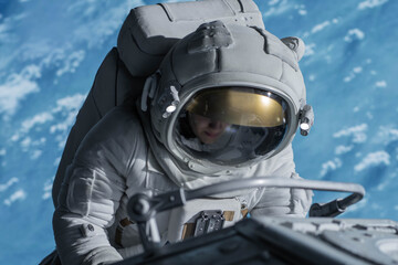 Wall Mural - female astronaut performing spacewalk, working on a outer part of a space craft