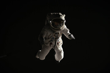 Wall Mural - full portrait of caucasian female astronaut during spacewalk, black deep space background