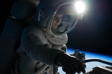 Wall Mural - female astronaut performing spacewalk, working on a outer part of a space craft