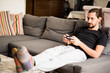 © Image Source - Man on sofa playing video game at home