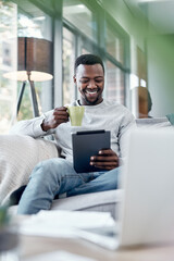 Poster - Movie time the mobile way. Shot of a young man using a digital tablet and having coffee on the sofa at home.