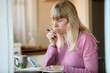 © Connect Images - Mature woman writing in note pad at home