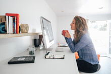Young Woman Working From Home On Desktop Pc