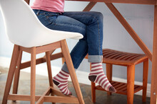Female Legs In Jeans And Striped Socks