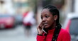 © Marco - Candid teenager speaking on phone outside. Black African young woman talking with cellphone
