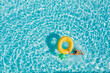 © Soloviova Liudmyla - Top view of a young female in swimsuit bikini in a straw hat on blue swimming pool waves background with big inflatable Yellow Pineapple tube. Chill out a summer vacation in luxury resorts concept.