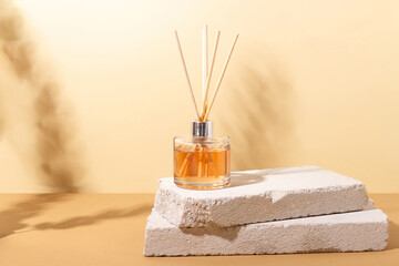 reed diffuser bottle on the podium. Incense sticks for the home with a floral scent with hard shadows. The concept of eco-friendly fragrance for the home