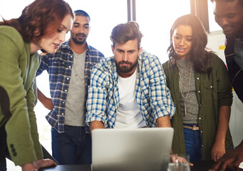 Canvas Print - Digital discussions in action. Shot of a group of colleagues working on a laptop in an office.