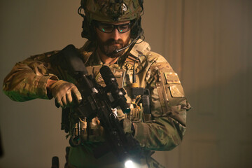 Bearded man in military equipment and glasses. Man in uniform holding machine gun, getting ready for combat. Military, army, airsoft concept