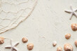 © tilialucida - Summer beach background with brown seashells, starfish and pebbles. Fisherman net and shells on textured cream color background. Summertime monochromatic flat lay with natural decor,copy-space.