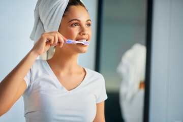 Poster - Welcome a new day with fresh breath. Shot of an attractive young woman brushing her teeth at home.