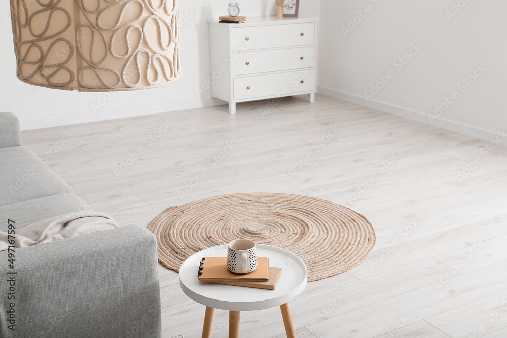 Round wicker carpet in interior of light living room