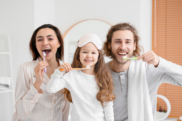 Wall Mural - Little girl with her parents brushing teeth in bathroom