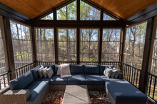 Cozy Screened Porch In Springtime, Full Of Blooms Trees In The Background.