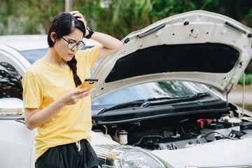 Asian woman having problem about her car breakdown and she trying to call insurance or someone to help her. Car breakdown it will happen to you at least once in your driving life.