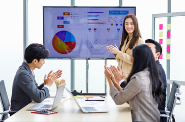 Asian young pretty professional successful businesswoman staff standing greeting say thank you when finishing presentation while male and female colleagues clapping hands together admire compliment