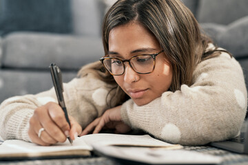 Poster - Its always a good idea to make a note of it. Cropped shot of a young woman wearing glasses while busy writing at home.
