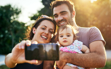 Wall Mural - Family selfie time. Shot of a young family outdoors.