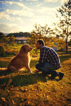 Spending Time With His Loyal Companion. Full Length Shot Of A Handsome Young Man And His Dog Spending A Day In The Park.