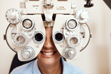 Wall Mural - I spy with my little eye. Shot of a young woman getting her eyes examined with an optical refractor.