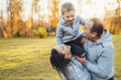 © Strelciuc - Little boy with father and mother enjoying free time together in park. Family day. Sunny day. Happy family.