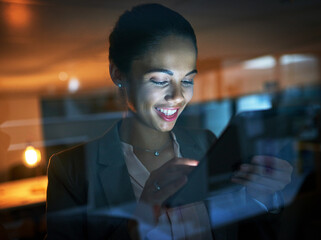 Poster - Making connections throughout the day and night. Shot of a young businesswoman using a tablet in the office at night.