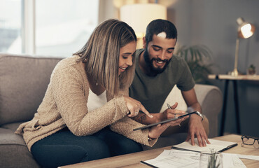 Poster - Improving their finances one tap at a time. Shot of a young couple sing a digital tablet while going through paperwork at home.