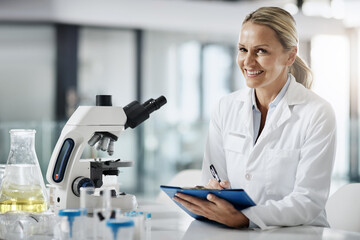 Sticker - Ive got something. Cropped portrait of an attractive mature female scientist taking down notes while doing research in her lab.