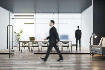 Aufkleber - Attractive young european businessman walking in modern concrete office interior with wooden flooring, matte partition glass, furniture, equipment and city view with daylight. Worker and ceo concept.