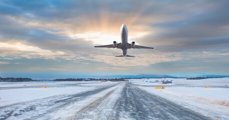 Wall Mural - Commercical white airplane fly up over take-off runway the (ice) snow-covered airport