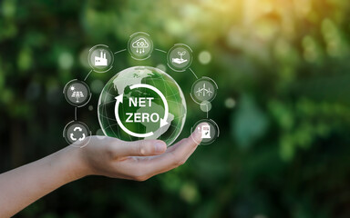 Net zero icon and carbon neutral concept in the hand for net zero greenhouse gas emissions target Climate neutral long term strategy on a green background.