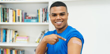 Smiling Hispanic Young Adult Man With Plaster After Vaccination Against Covid 19
