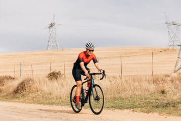 Wall Mural - Professional athlete cycling on countryside. Cyclist riding bike.