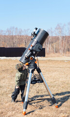Wall Mural - child boy near big black telescope on a tripod at the observatory for observation of stars and plane