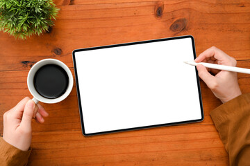 Poster - Top view, Female hands holding a cup of coffee and sketching graphic artwork on tablet