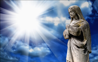 Fototapete - Virgin Mary.  Vintage ancient statue of sad woman against blue sky in sunbeams