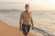 © Johnér - Senior man walking on beach in protective face mask
