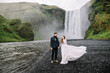 Stylish Bride and groom on elopement near Skogafoss waterfall. Iceland wedding
