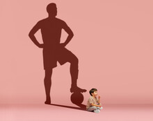 Little Boy Dreams Of Becoming A Football Player Isolated On Pink Background. Childhood And Dreams Concept. Collage.