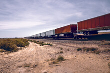 Beautiful Shot Of A Goods Train On The Desert With Blue Cloudy Sky On A Sunny Day