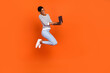 Photo of cute charming third gender person wear pullover jumping typing device empty space isolated orange color background