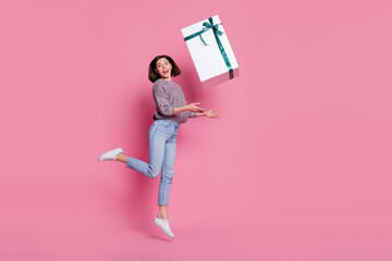 Poster - Full length body size view of attractive cheerful girl jumping throwing big giftbox isolated over pink pastel color background