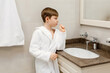 © Anna - A child is brushing his teeth in the bathroom. A child in a white coat is brushing his teeth. Healthy lifestyle. Healthy teeth.