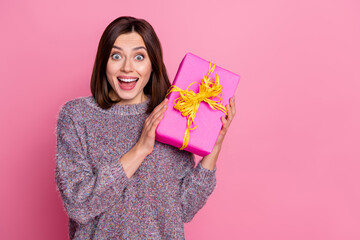Wall Mural - portrait of attractive amazed cheerful girl holding in hands festal gift occasion isolated over pink